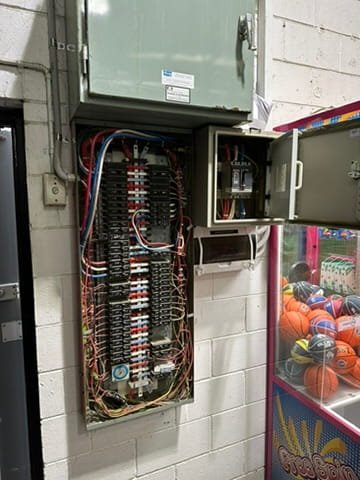 Old black meter box on brick wall before switchboard upgrade, Beaconsfield VIC. Pro Fit Electrics.